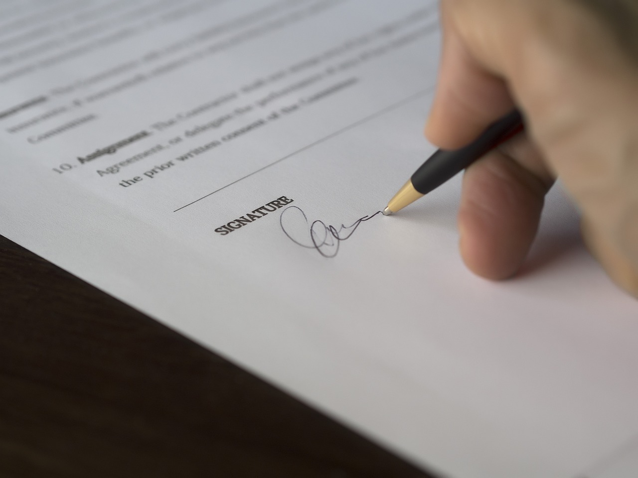 Editorial photo for What to Do If Someone Stops Paying Under a Handshake Agreement, showing business contracts, invoices, and settlement paperwork.